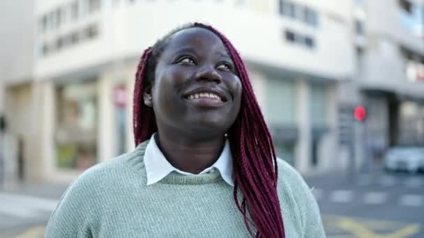 通りで横に自信を持って笑顔編組髪を持つアフリカの女性 — ストック動画