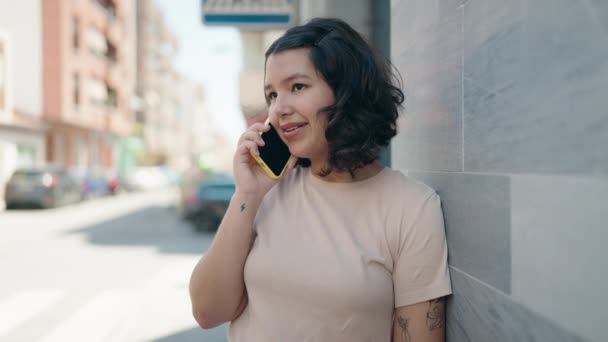 在智能手机上说话的年轻女人看着街上的手表 — 图库视频影像