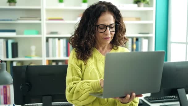 Middle Age Hispanic Woman Teacher Using Laptop Studying Library University — Vídeo de Stock