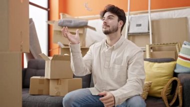 Yeni evin anahtarlarını elinde tutarak gülümseyen İspanyol genç adam.