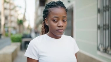 Sokakta ciddi bir ifadeyle duran Afrikalı Amerikalı kadın.