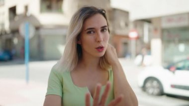 Sokakta video araması yapan kendine güvenen genç bir kadın.