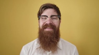 Young redhead man smiling confident wearing glasses over isolated yellow background