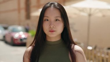 Young chinese woman smiling confident standing at street