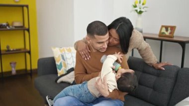 Evde biberonla süt içen çift ve oğul.