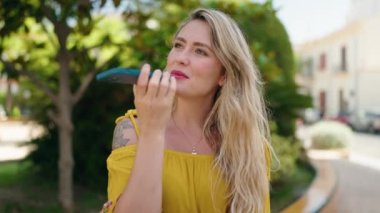 Parktaki akıllı telefondan konuşan, kendine güvenen genç bir kadın.