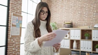 Young beautiful hispanic woman business worker standing with relaxed expression at office