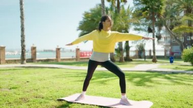 Genç Afrikalı Amerikalı kadın parkta yoga eğitimi alıyor.