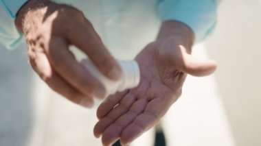 Yaşlı gri saçlı adam sokakta hap tutuyor.