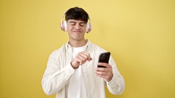 Młody Hiszpan Słuchający Muzyki Tańczącej Odizolowanym Żółtym Tle — Wideo stockowe