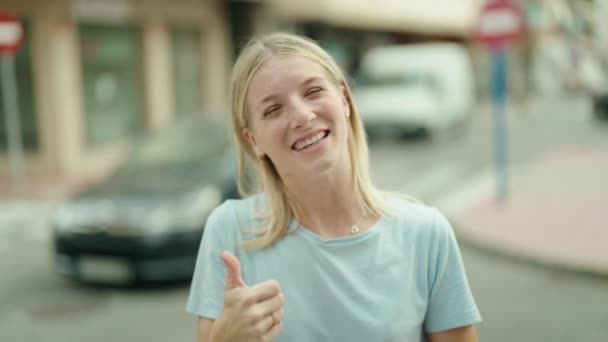 Młoda Blondynka Uśmiecha Się Pewnie Robi Znak Kciuki Górę Ulicy — Wideo stockowe