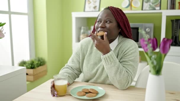 Mulher Africana Com Cabelo Trançado Comer Biscoito Sentado Mesa Sala — Vídeo de Stock