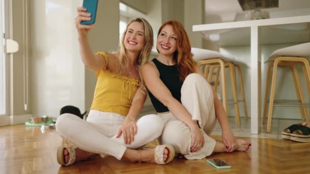 Δύο Γυναίκες Κάνουν Selfie Από Smartphone Κάθεται Στο Πάτωμα Στο — Αρχείο Βίντεο