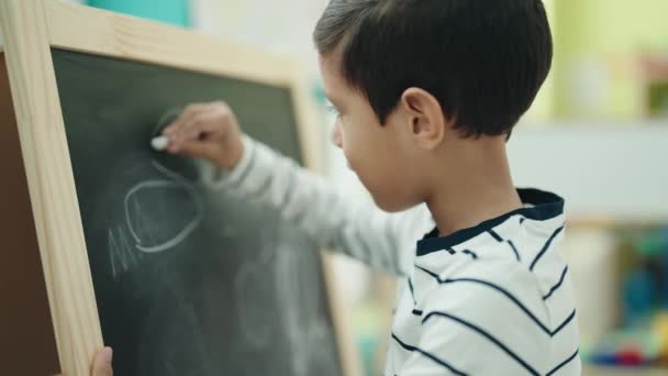 Entzückender Hispanischer Junge Vorschulalter Zeichnet Auf Einer Tafel Klassenzimmer — Stockvideo