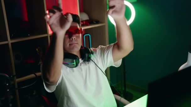 若いですヒスパニック男ストリーマーゲームルームで仮想現実のメガネを使用してビデオゲームをプレイ — ストック動画