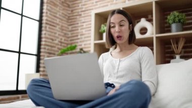 Genç, güzel, İspanyol bir kadın yatak odasında video görüşmesi yapıyor.