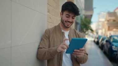 Sokakta dokunmatik ped kullanan, kendine güvenen İspanyol genç adam.