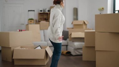 Middle age woman smiling confident dancing at new home
