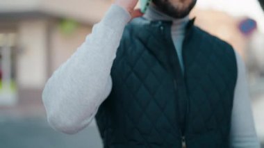 Genç İspanyol adam gülümsüyor. Kendine güveniyor. Sokakta akıllı telefondan konuşuyor.