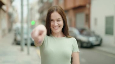 Young beautiful woman smiling confident doing coming gesture with hand at street