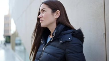 Young caucasian woman standing with serious expression at street