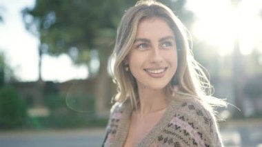 Sokakta kendine güvenen genç sarışın kadın gülümsüyor