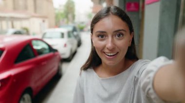 Genç, güzel, İspanyol bir kadın gülümsüyor.