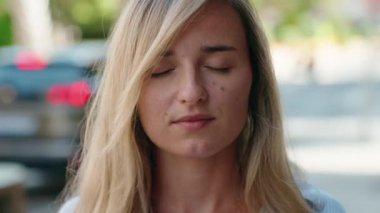 Sokakta kendine güvenen genç sarışın kadın gülümsüyor