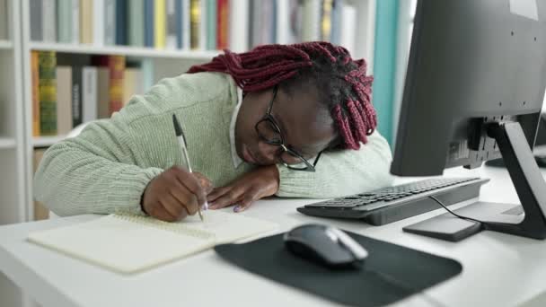 アフリカ人女性とともに編組髪学生書きノート疲れていますで大学図書館 — ストック動画