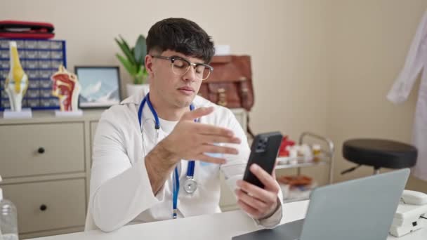 Młody Latynos Człowiek Lekarz Robi Wideo Rozmowy Smartfonem Klinice — Wideo stockowe