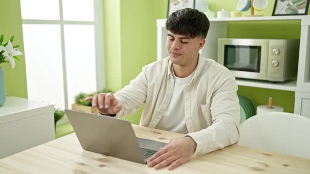 Молодий Іспаномовний Чоловік Використовує Ноутбук Сидячи Столі Їдальні — стокове відео