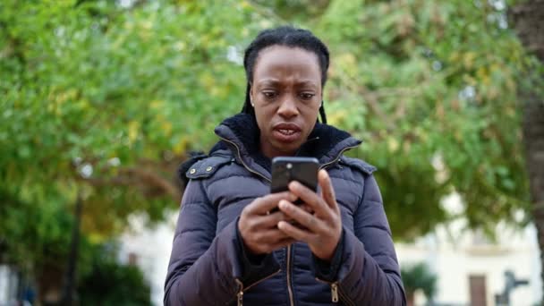 Femme Afro Américaine Utilisant Smartphone Avec Une Expression Sérieuse Parc — Video