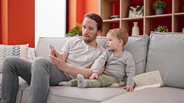 Père Fils Utilisant Smartphone Assis Sur Canapé Ensemble Maison — Video