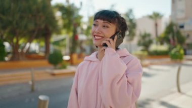 Genç İspanyol kadın gülümsüyor. Kendine güveniyor. Akıllı telefondan konuşuyor.