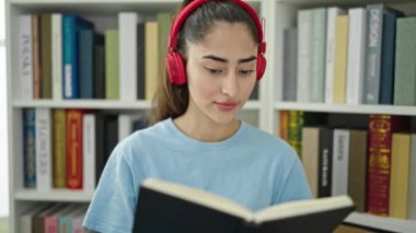Kütüphane üniversitesinde müzik dinleyen güzel İspanyol bir kız öğrenci.
