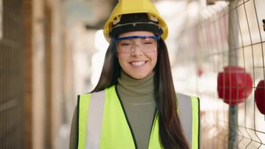 Young hispanic woman architect smiling confident standing at construction site