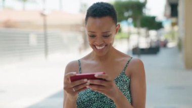 Afro-Amerikalı kadın akıllı telefon kullanıyor.