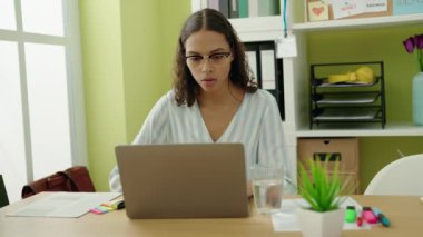 Ofiste çalışan genç Afro-Amerikan iş kadını laptopu kullanıyor.