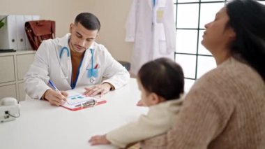 Çift ve oğul gülümseyerek klinikte kendinden emin bir şekilde el sıkışıyor