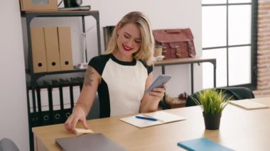 Genç, güzel İspanyol iş kadını. Ofisteki defterde akıllı telefon yazıları kullanıyor.