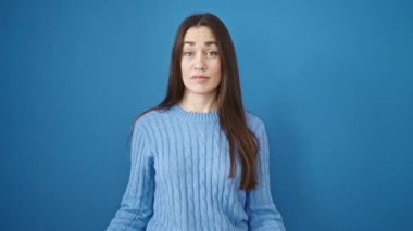 Kafkasyalı genç bir kadın kendini göstererek, izole edilmiş mavi arka planda parmağıyla hayır diyor.