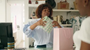 Afro-amerikan kadın alışveriş asistanı ve alışveriş torbası.