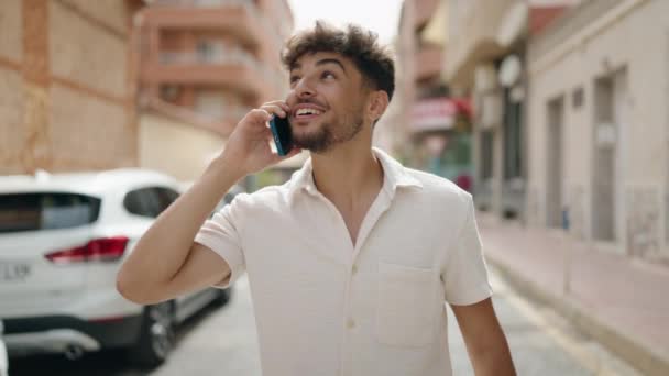 年轻的阿拉伯男子微笑着 自信地在街上用智能手机交谈 — 图库视频影像