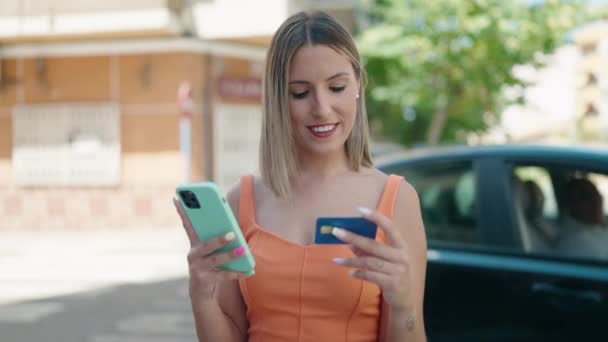 年轻美丽的惊慌失措的女人在街上用智能手机和信用卡 — 图库视频影像