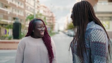 Two african american women smiling confident speaking at street