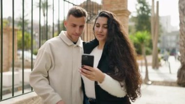 Young couple smiling confident making selfie by the smartphone at street