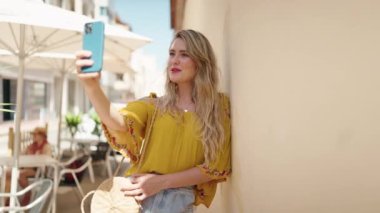 Sokakta video araması yapan kendine güvenen genç bir kadın.