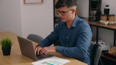 Young hispanic man business worker using laptop working at office