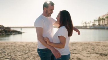 Man and woman couple hugging each other standing at beach