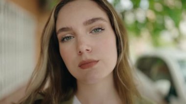 Sokakta duran rahat yüzlü genç kadın.